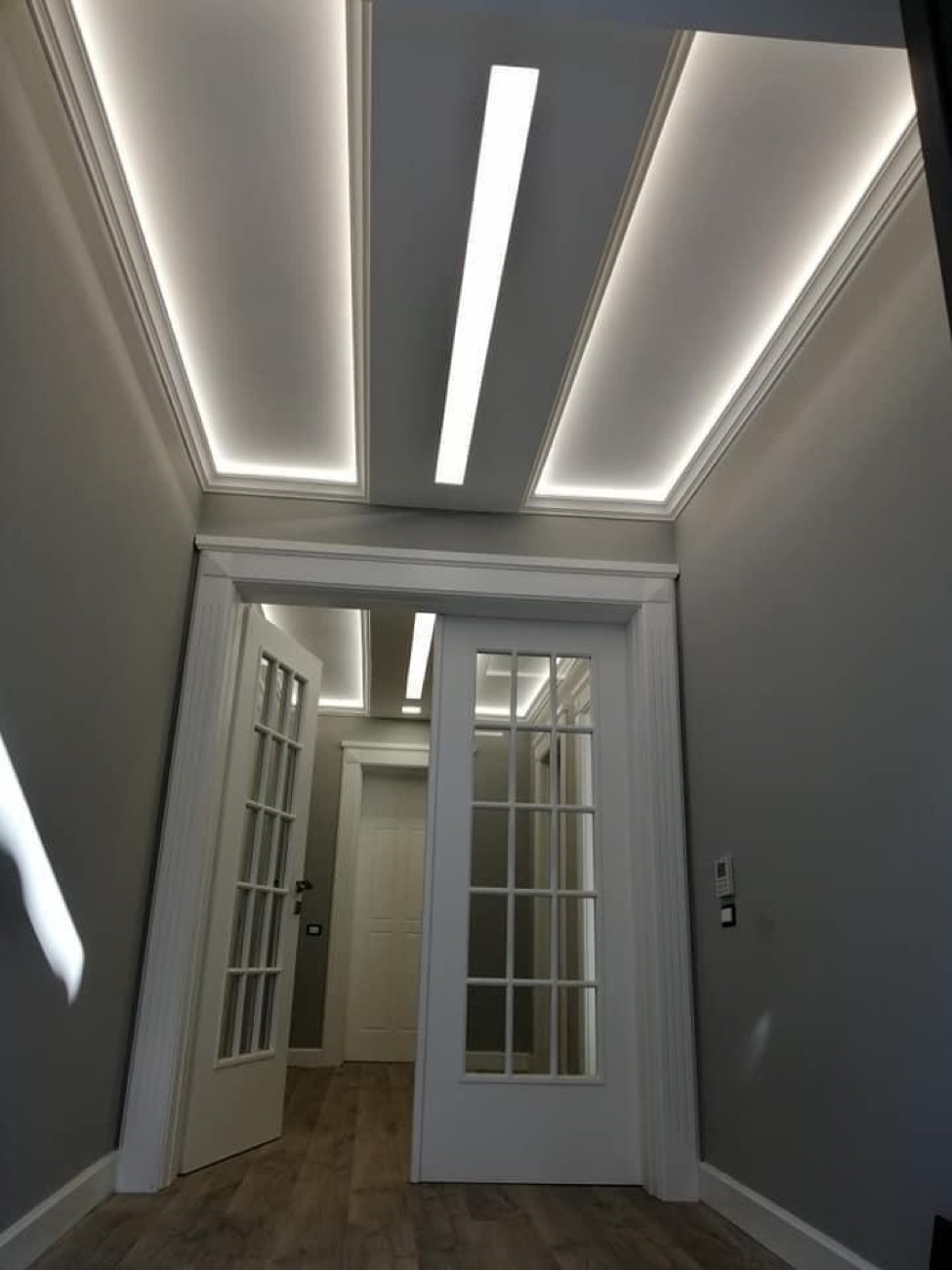 Eleganter Flur mit indirekter Beleuchtung und klassischen Türen