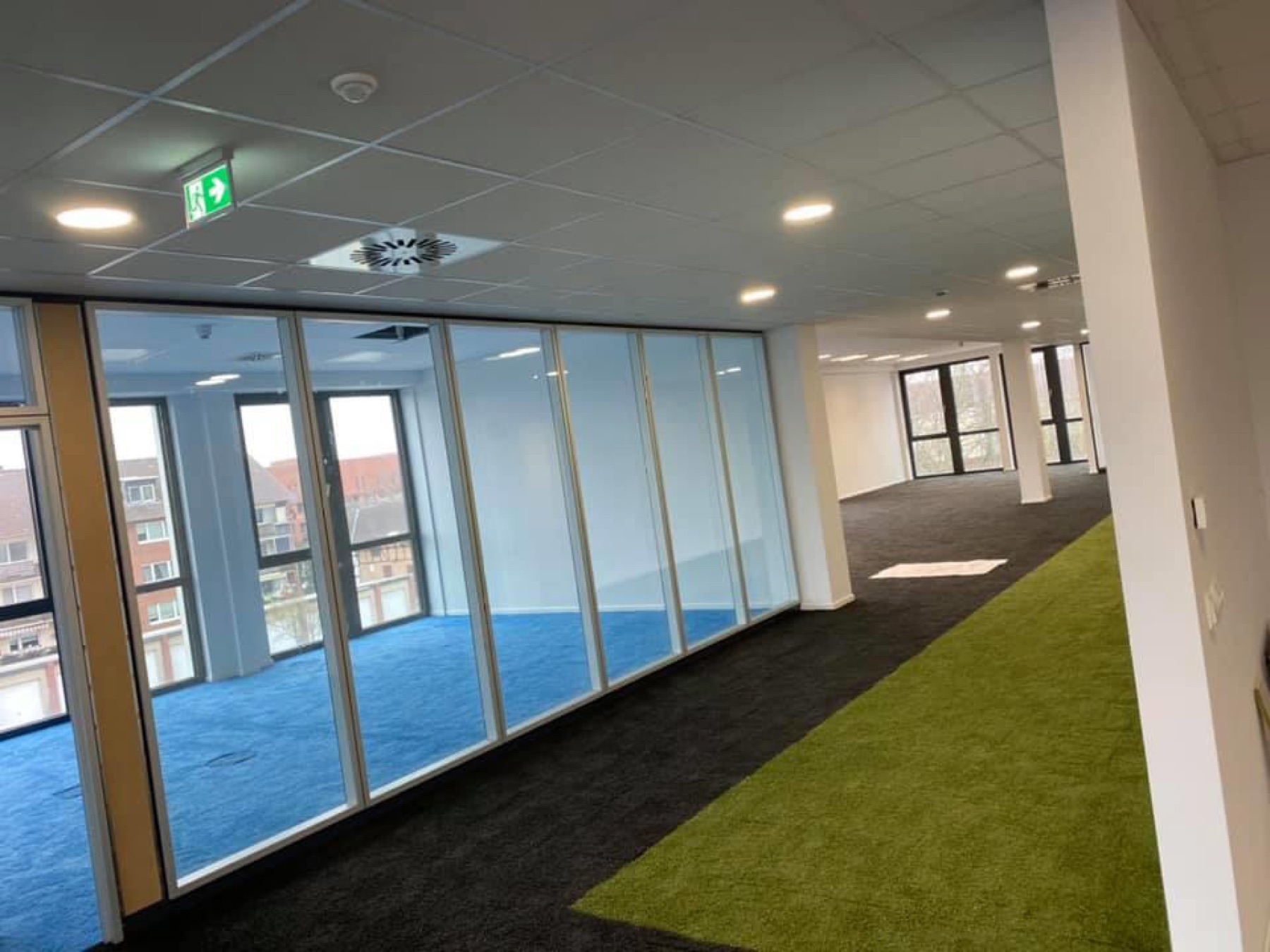 Fertiggestellte Bürofläche mit Glastrennwand, Akustikdecke und Teppichboden – Innenausbau von KR-M Bau