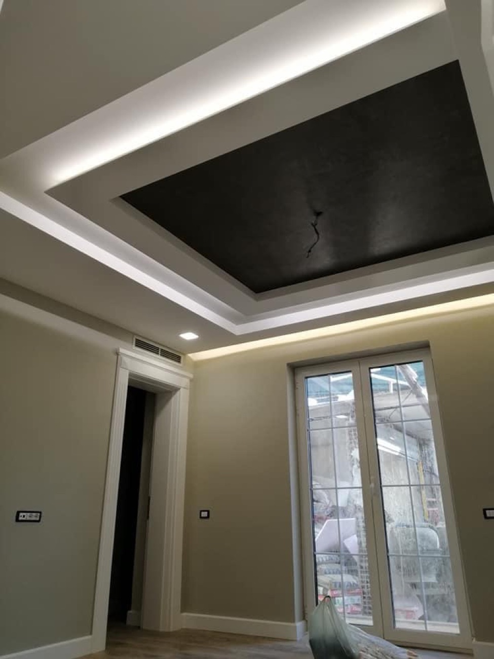 Raum mit schwarzer LED-Decke und klassischen Türen